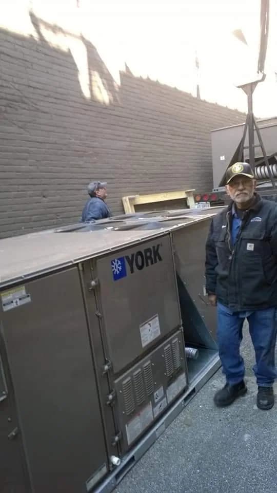 ERV/HRV Installation — technicians inspecting a commercial rooftop HVAC unit