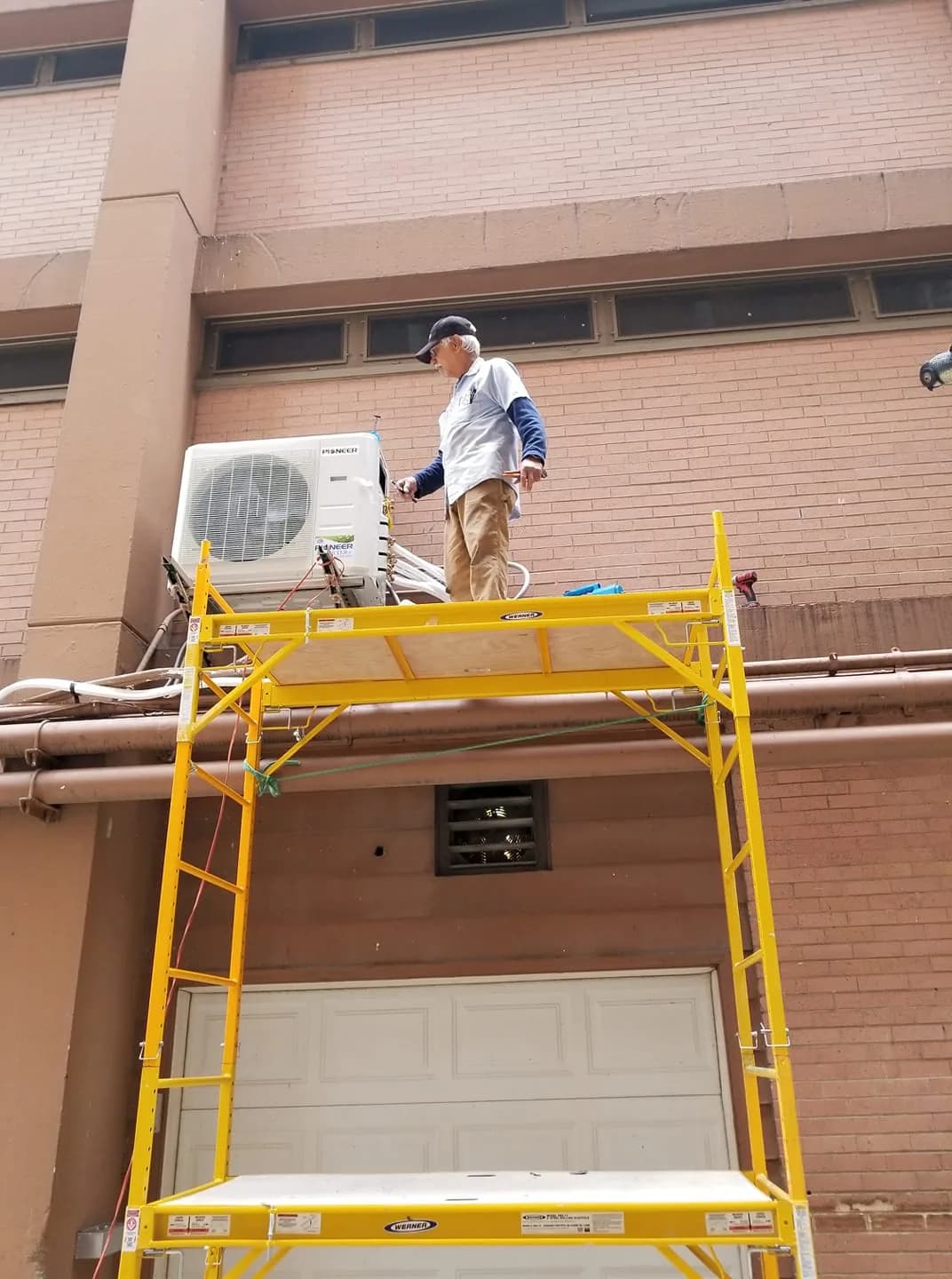 Seasonal HVAC Maintenance Plans Chicago — technician servicing an elevated commercial mini-split outdoor unit