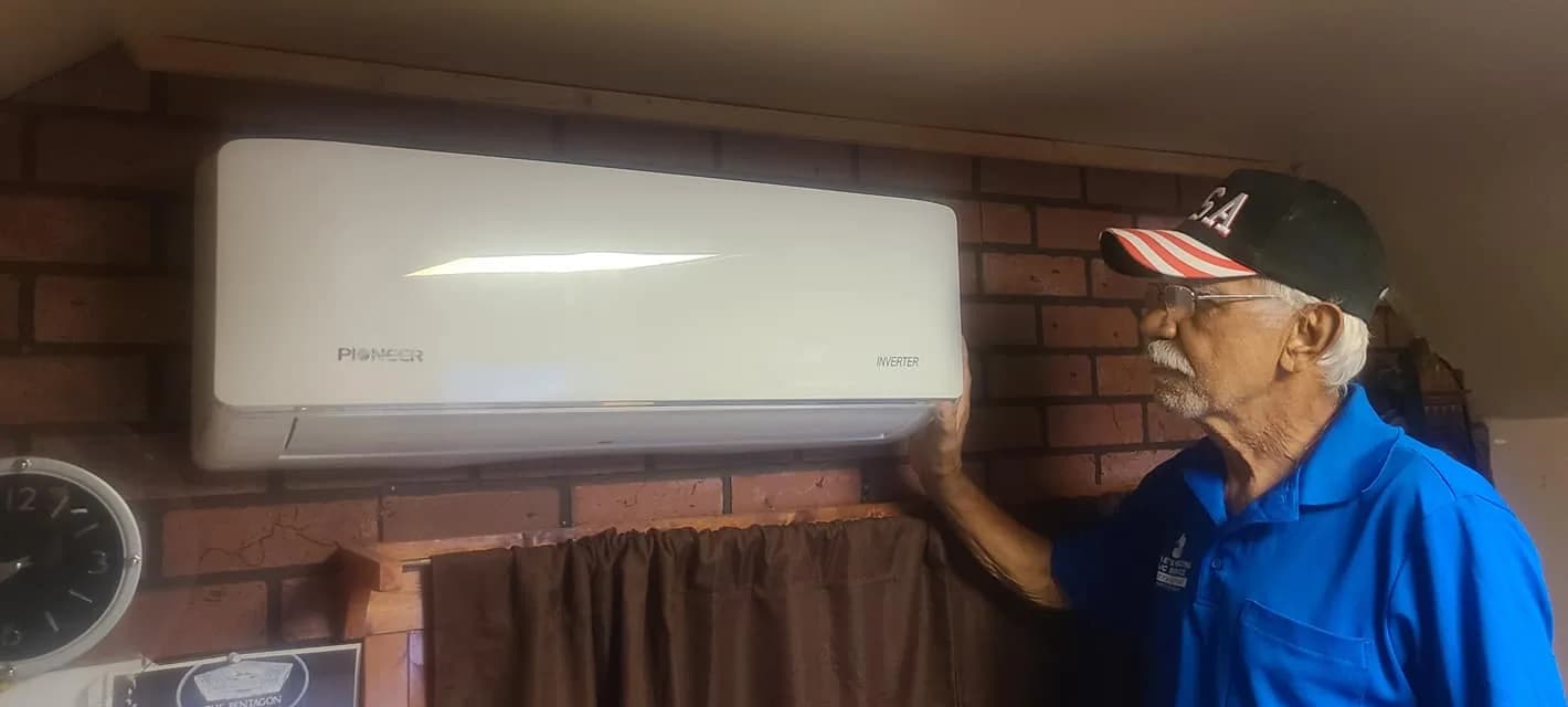 Air Purifier Installation Chicago — Bernie's technician beside an indoor ductless mini-split unit