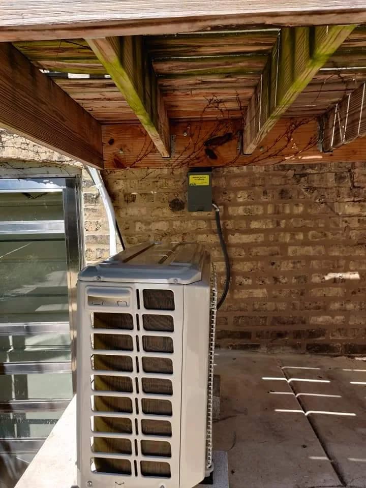 Heat Pump Installation & Repair Chicago — ductless mini-split outdoor unit installed beneath a deck