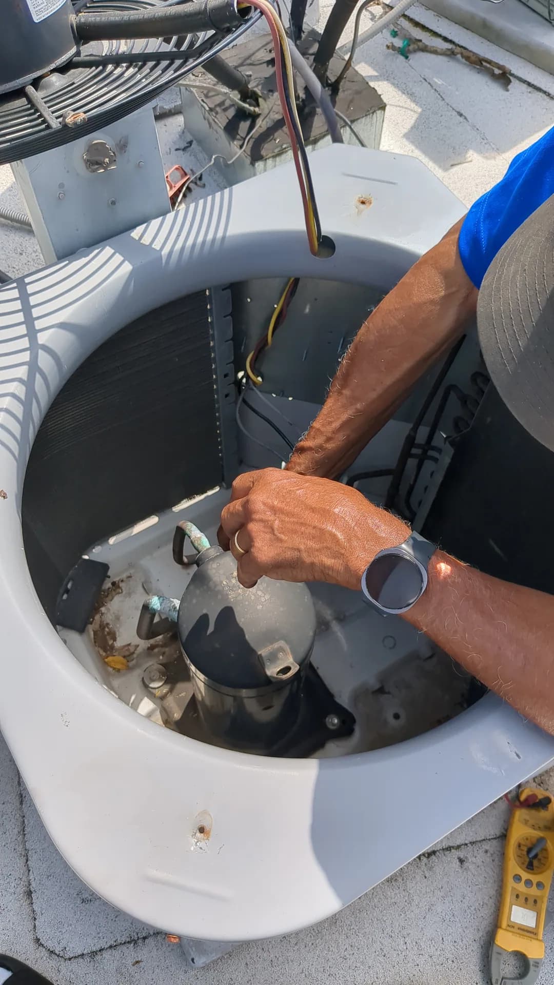 AC Compressor Repair & Replacement — technician working inside an open air-conditioning condenser
