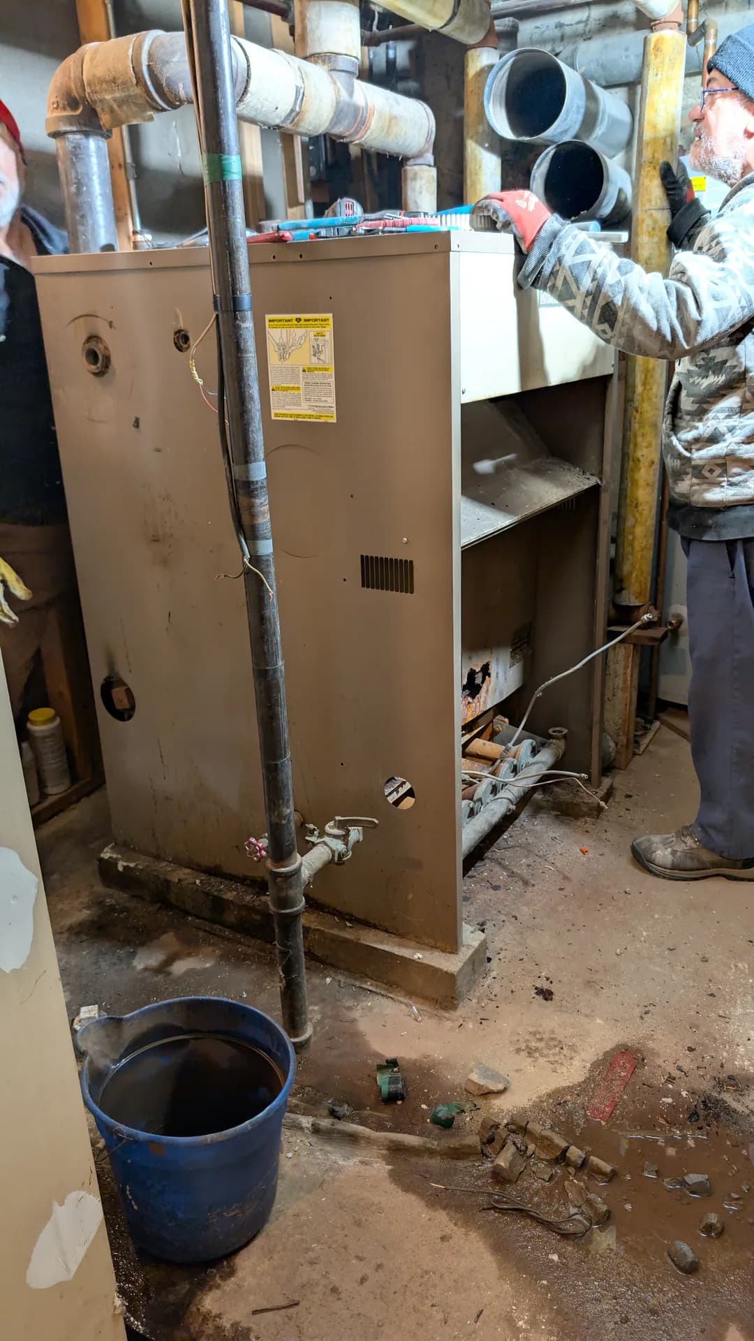Furnace Ignition & Pilot Light Repair Chicago — technician working inside an old boiler cabinet during removal