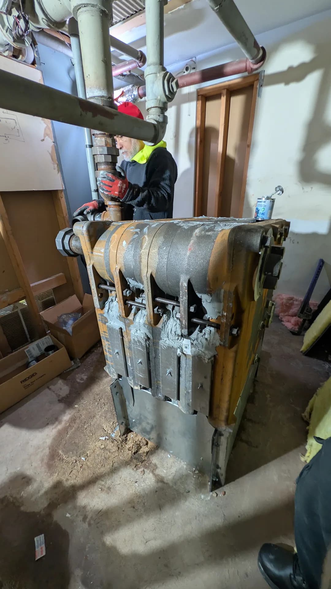 Boiler Leaking Water in Chicago — technician disconnecting piping from an old steam boiler